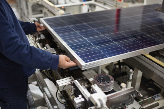 Production,Of,Solar,Panels,,Man,Working,In,Factory.