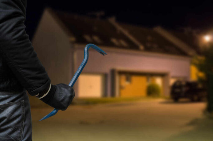 Crime,Concept.,Burglar,Or,Robber,With,Crowbar,Stands,In,Front