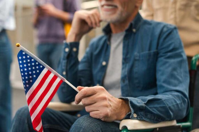 Happy,Elderly,Male,Voter,Sitting,In,Wheelchair,Holding,American,Flag,
