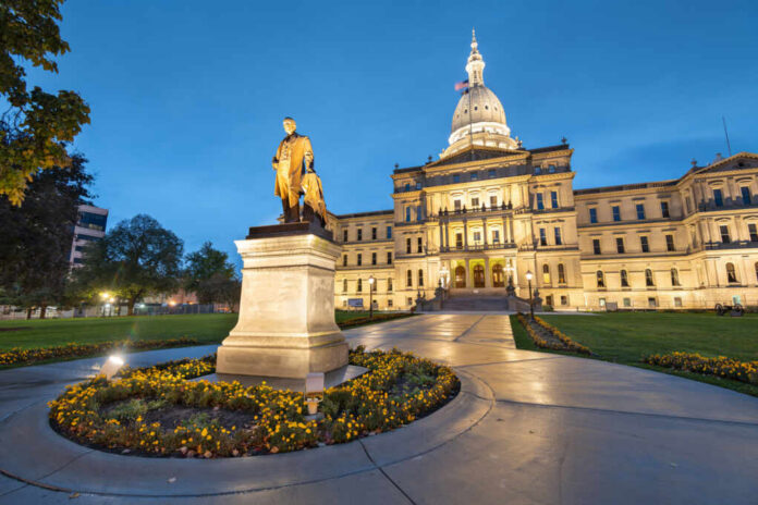 Statue in front of a state capitol building at dusk