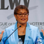 A female politician speaking passionately at a podium during a conference