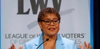 A female politician speaking passionately at a podium during a conference