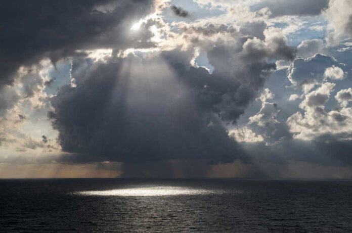 Dramatic clouds with sunlight rays over the ocean
