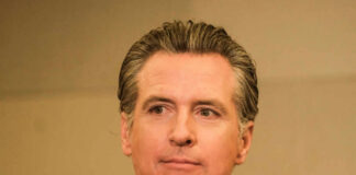 A man in business attire with a serious expression, captured in a medium shot