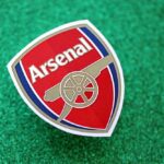 Arsenal football club logo on a green glitter background