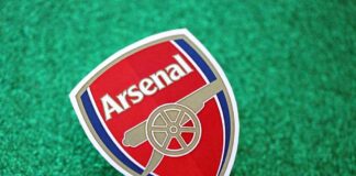 Arsenal football club logo on a green glitter background