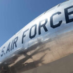 Close-up of a U.S. Air Force aircraft with a shiny metallic surface against a blue sky