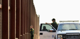 U.S. Customs and Border Protection officers near a border fence