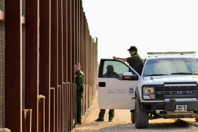 U.S. Customs and Border Protection officers near a border fence