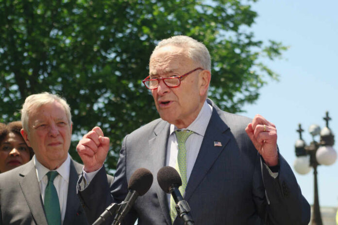 A politician speaking passionately at a press conference with microphones in front