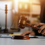 A gavel being struck on a desk in a courtroom setting