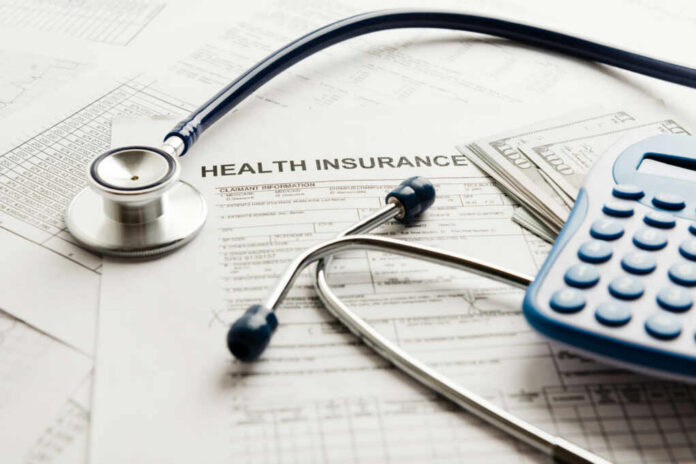 Stethoscope and calculator on health insurance documents
