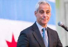 A man in a suit speaking at a podium with a microphone