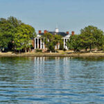 Historic mansion surrounded by trees with a waterfront view