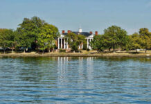 Historic mansion surrounded by trees with a waterfront view