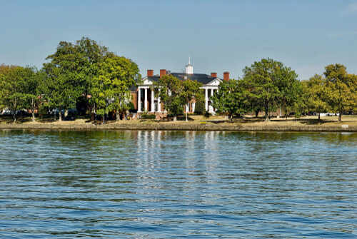 shutterstock_1540884284 (1).jpg Historic mansion surrounded by trees with a waterfront view