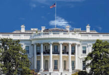 $400M White House Ballroom Sparks Uproar The White House with an American flag flying against a blue sky