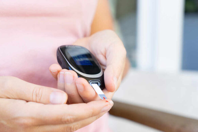 shutterstock_1949733853.jpg Person using a blood glucose meter to check their levels