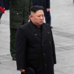 A political figure in formal attire participating in a solemn ceremony