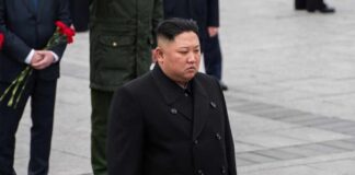 A political figure in formal attire participating in a solemn ceremony