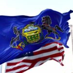Pennsylvania state flag waving alongside the American flag