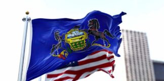 Pennsylvania state flag waving alongside the American flag