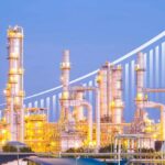 Illuminated industrial oil refinery with a growth graph overlay