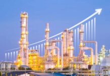 Illuminated industrial oil refinery with a growth graph overlay