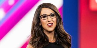 A woman in glasses speaking at a conference