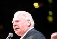 A politician speaking into a microphone at an event