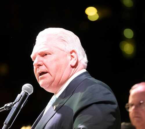 A politician speaking into a microphone at an event