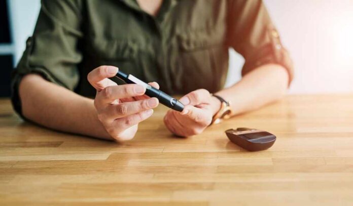 Person using a blood glucose meter and a pen device for diabetes management