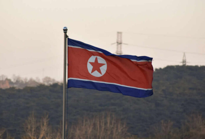 North Korean flag waving against a mountainous backdrop