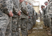 A line of soldiers in military uniforms standing outdoors in formation
