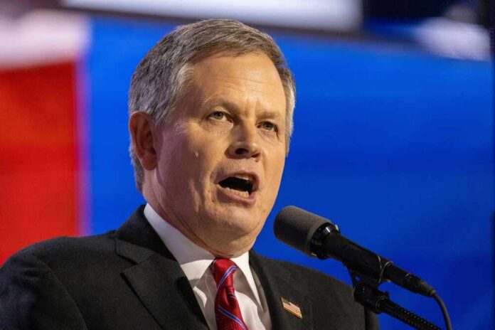 A man in a suit speaking passionately into a microphone at a political event
