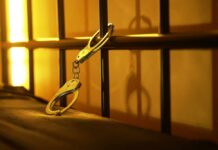 Close-up of handcuffs attached to a bed frame