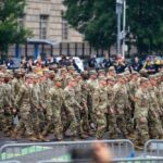 A group of soldiers in military uniforms marching in formation during a parade