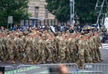 A group of soldiers in military uniforms marching in formation during a parade