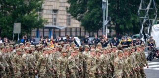 A group of soldiers in military uniforms marching in formation during a parade
