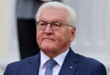 Germany SLAMS US-Israel War – Illegal, Disaster! A senior political figure in formal attire with a serious expression