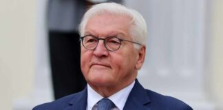 Germany SLAMS US-Israel War – Illegal, Disaster! A senior political figure in formal attire with a serious expression