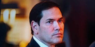 A serious-looking man in formal attire with a focused gaze