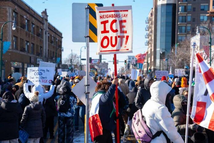 shutterstock_2718210697.jpg Crowd of protesters holding signs at a rally against ICE