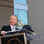 A man speaking at a podium during a Hollywood Walk of Fame ceremony