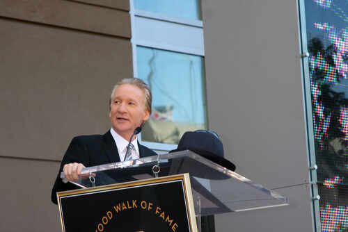 A man speaking at a podium during a Hollywood Walk of Fame ceremony