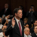 A man raising his right hand during a congressional hearing