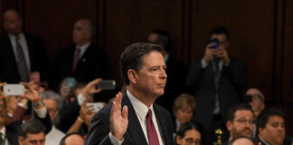 A man raising his right hand during a congressional hearing