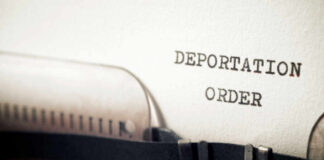 Close-up of a typewriter with a paper showing the words DEPORTATION ORDER