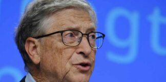 A man in a suit speaking at a conference with a microphone