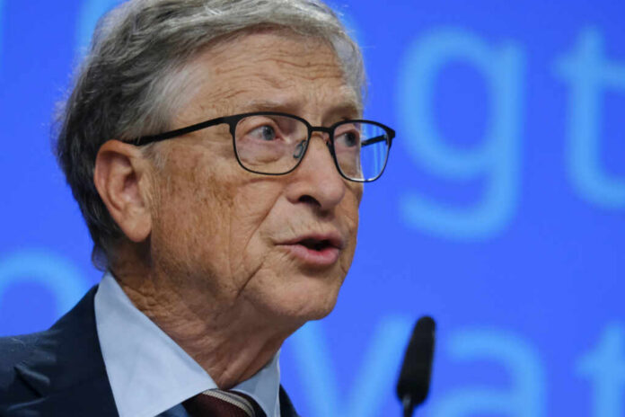 A man in a suit speaking at a conference with a microphone